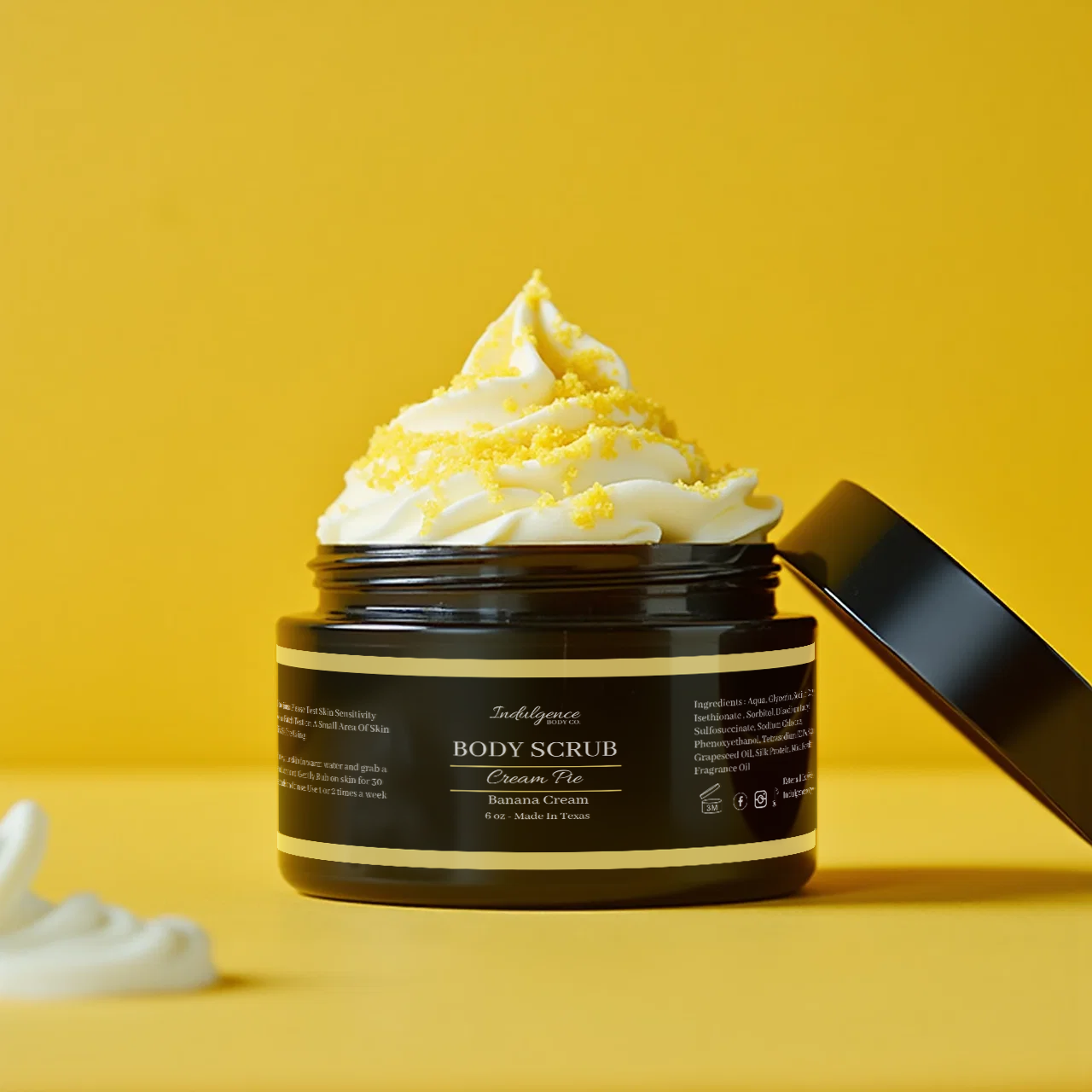 Black jar of body scrub with whipped cream on a yellow background
